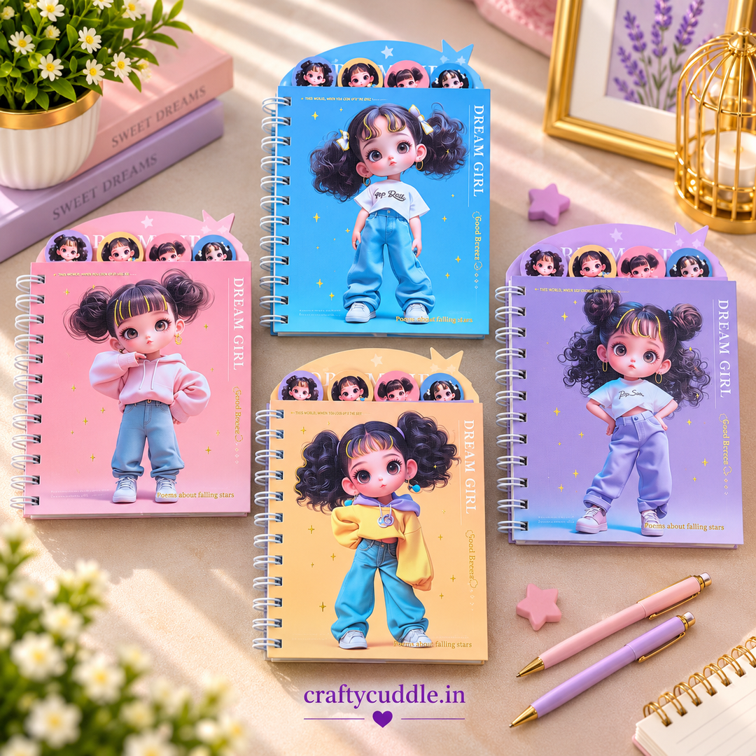 Four spiral-bound notebooks with cartoon girl covers are arranged on a beige tabletop with decorative props including flowers, books, a gold birdcage, and two pastel pens. The covers are pink, blue, yellow, and purple, each featuring a large illustrated character and the text &