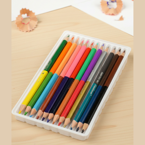 Set of colored pencils in a white box on a wooden surface