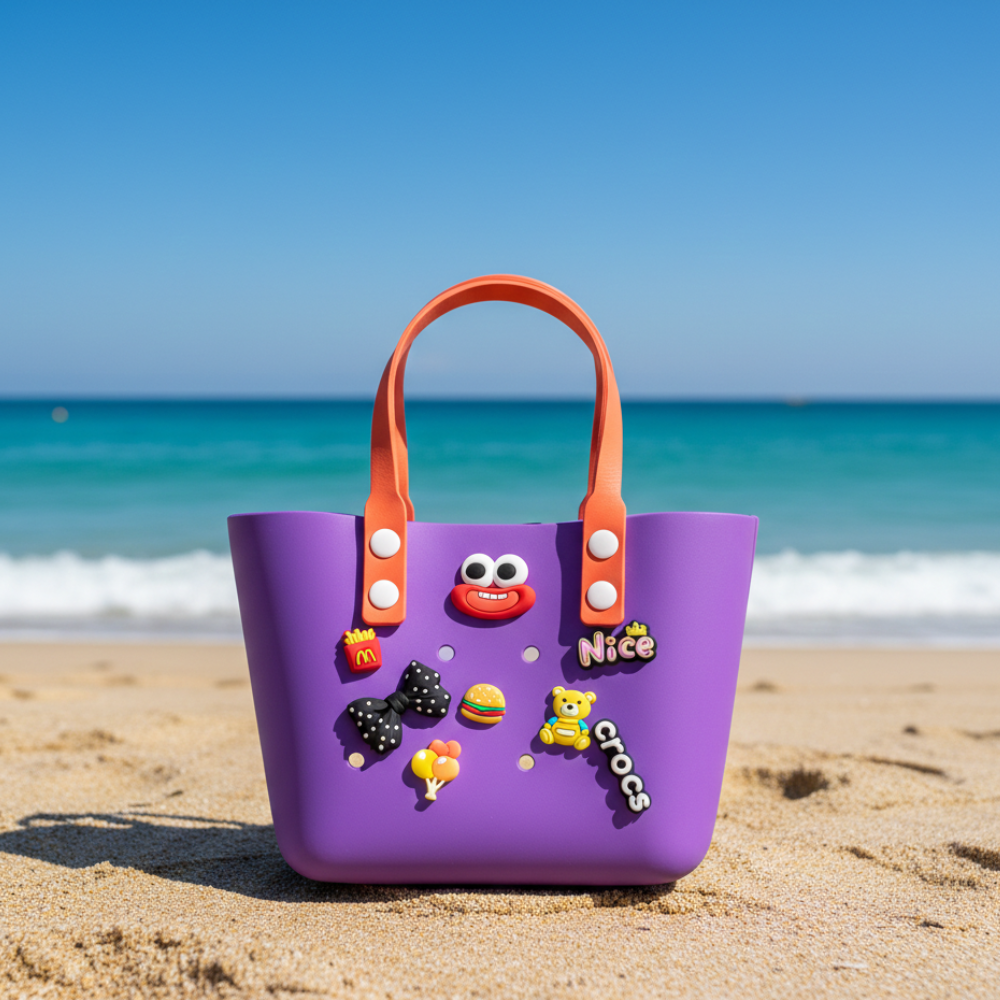Purple children's bag with orange handles on a sandy beach with ocean in the background