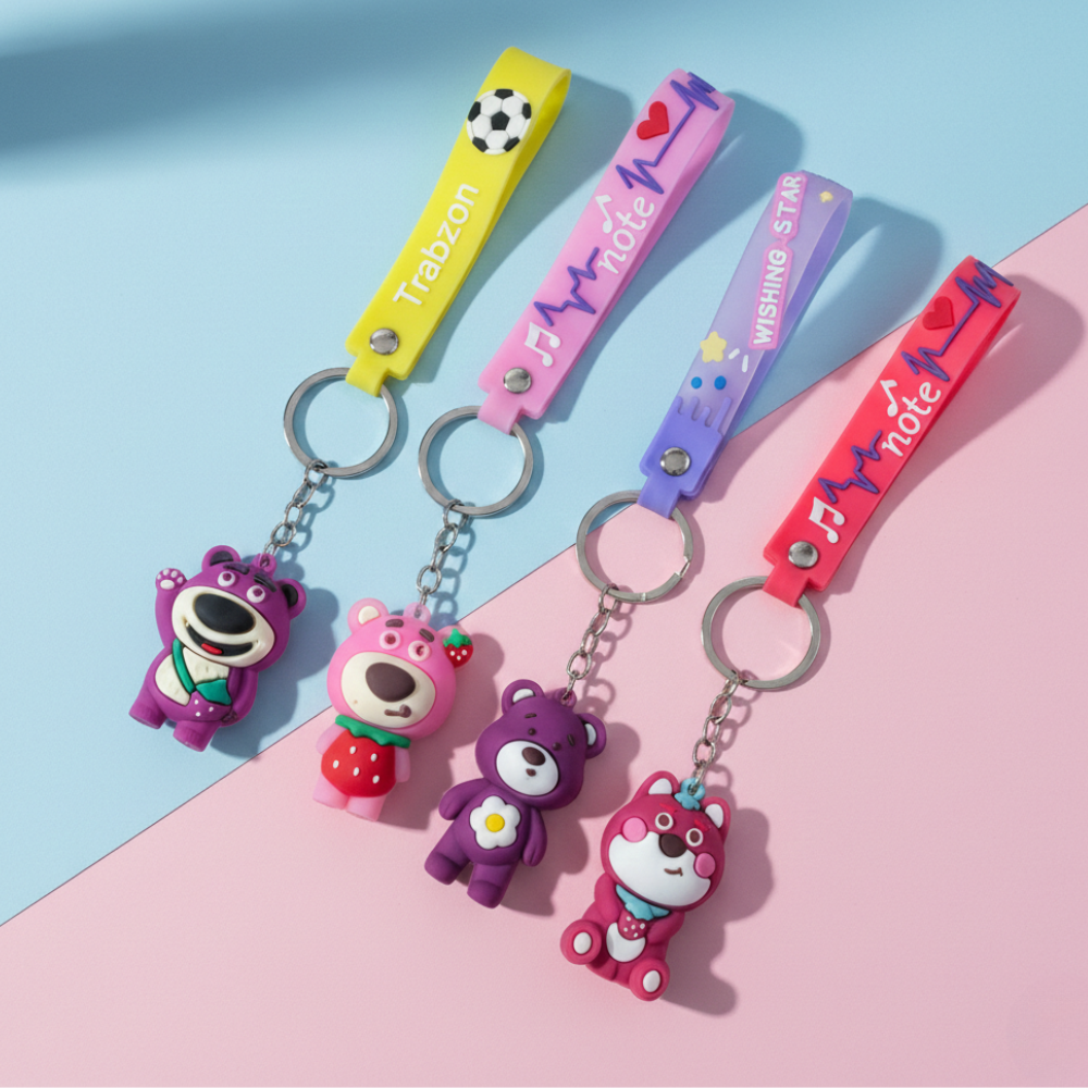 Colorful keychains with bear figures on a pink and blue background