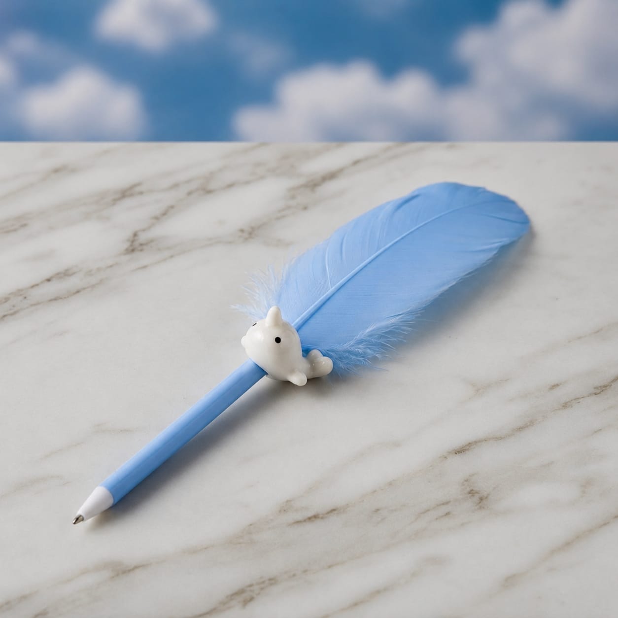 A light blue pen with a large light blue feather attached near the top and a small white animal figurine, resembling a fox or rabbit, perched on the pen. The pen is placed on a white marble surface with a blue sky and clouds backdrop.