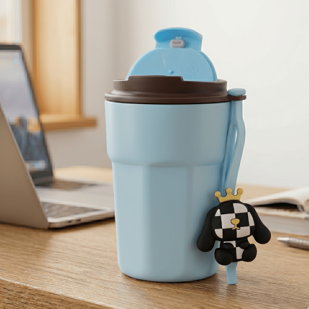 Cartoon Charm Insulated Coffee TumblerInsulated Coffee TumblerCrafty CuddleLight blue travel mug with a brown lid on a desk next to a laptopBlackCuteTumbler AestheticCups TrendyDrinkware PastelVibes KawaiiStyle ReusableCup HydrationGoals CuteAccessories GiftIdeas HomeEssentials