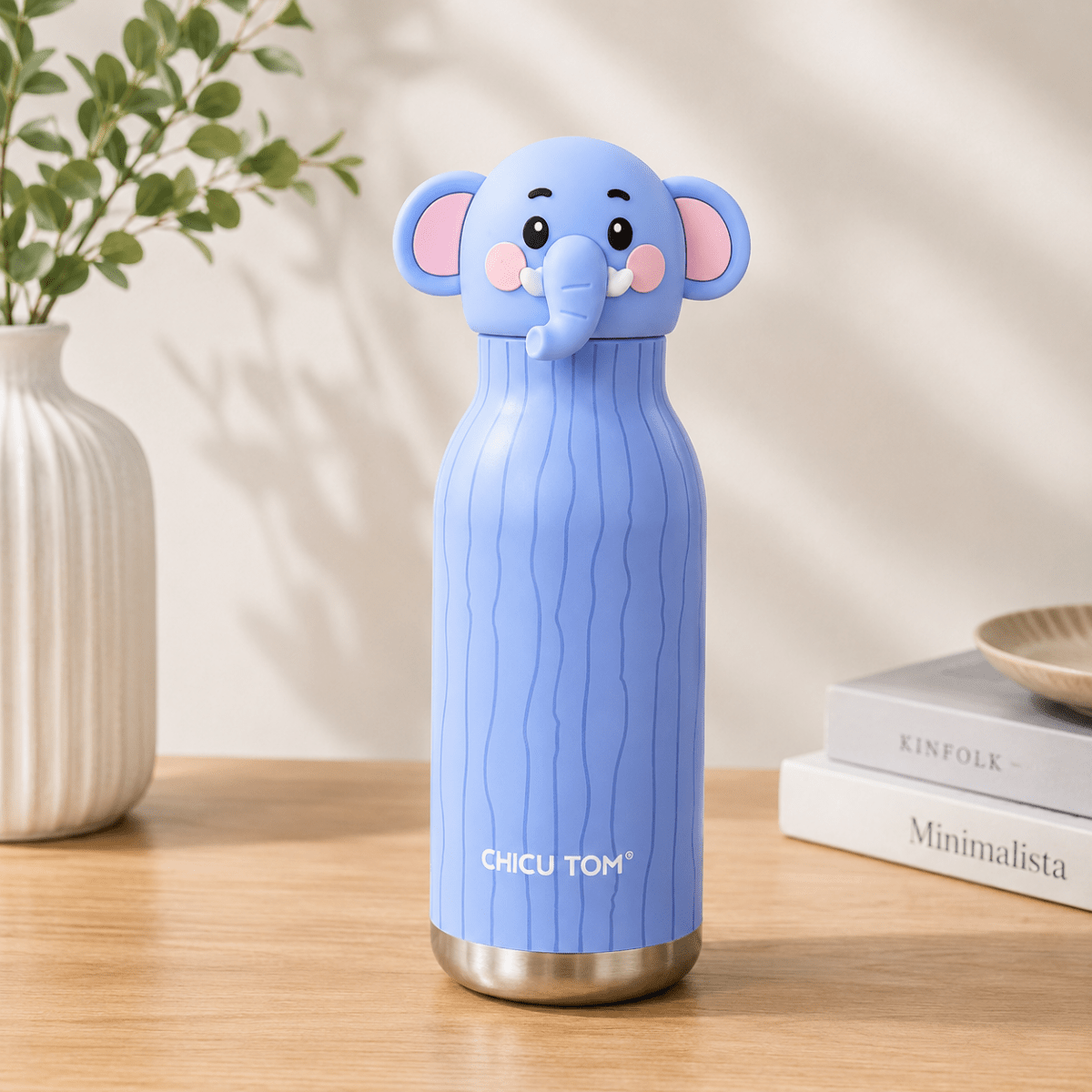 Cute Animal Water BottleCartoon Kids Water BottleCrafty CuddleA light blue insulated water bottle with a 3D elephant lid, standing on a wooden table with a white vase and books in the background.Baby ElephantCuteWaterBottle KidsWaterBottle ThermosFlask InsulatedBottle StainlessSteelBottle BackToSchoolEssentials CuteStationery KidsLifestyle ReusableBottle ChicuTomStationeryAddict