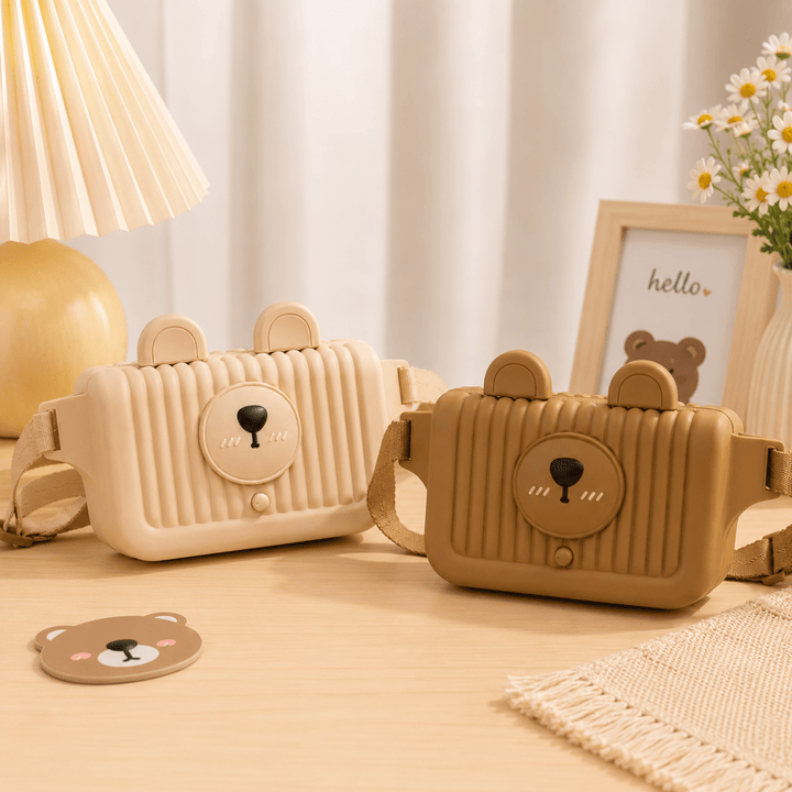 Cute Bear Kids Waist BagKids BagsCrafty CuddleTwo cute bear-face shoulder bags in cream and tan are displayed on a light wooden table with a decorative lamp, flowers, and a small framed picture in the background.BeigeKidsBag BearBag CrossbodyBag WaistBag ChestBag KidsFashion CartoonBag EVABag TravelWithKids CuteAccessoriesStationeryAddict
