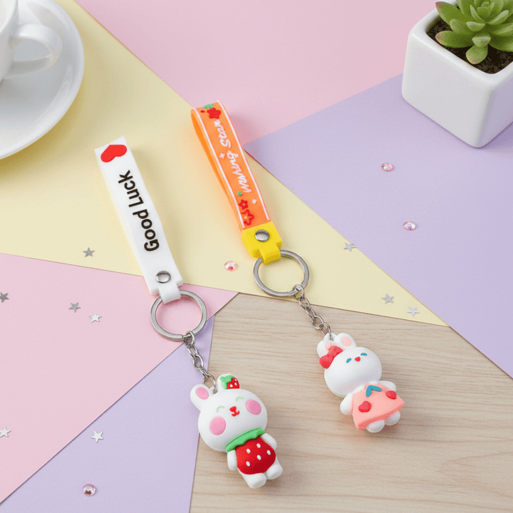 Cute Bunny KeychainKeychainsCRAFTY CUDDLETwo keychains on a colorful geometric - patterned surface with a small plant in the background.1BunnyKeychain CuteKeyring KawaiiAccessories GirlsBagCharm CartoonKeychain KidsReturnGifts BackpackCharm RabbitKeychain TrendyKeyrings GiftForGirls