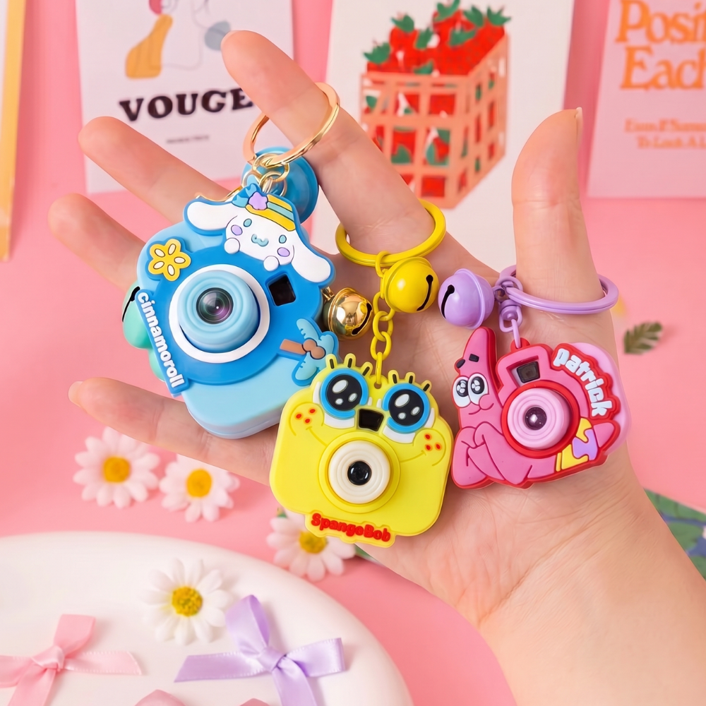 Cute Camera Shape Projector KeychainKeychainsCrafty CuddleThree camera keychain with a bell on a pastel background BlueCuteKeychain KawaiiAccessories KidsAccessories ReturnGiftIdeas CartoonKeychain MiniCamera BagCharm StationeryLove GiftForKids TrendingNow