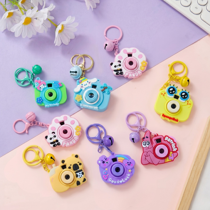 Cute Camera Shape Projector KeychainKeychainsCrafty CuddleColorful camera - shaped keychains on a pink and purple background with flowers.BlueCuteKeychain KawaiiAccessories KidsAccessories ReturnGiftIdeas CartoonKeychain MiniCamera BagCharm StationeryLove GiftForKids TrendingNow