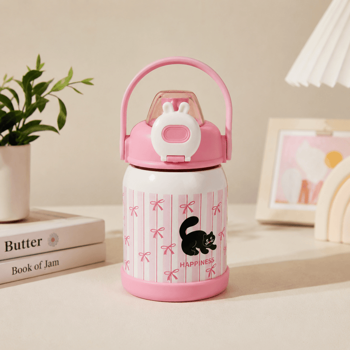 Cute Cartoon Water BottleCartoon Kids Water BottleCrafty CuddlePink and white thermos with black cat design on a table with books and a plant.PinkKidsWaterBottle SchoolBottle InsulatedWaterBottle StrawBottle LeakproofBottle KidsLifestyle SchoolEssentials GiftForKids CuteKidsProducts CraftyCuddleStationeryAddict