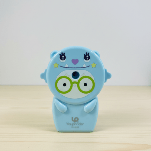 Cute Pastel Pencil Sharpener for KidsStationery > Erasers &amp; SharpenersCRAFTY CUDDLECute blue cartoon character with glasses on a light wooden surfaceLight Green