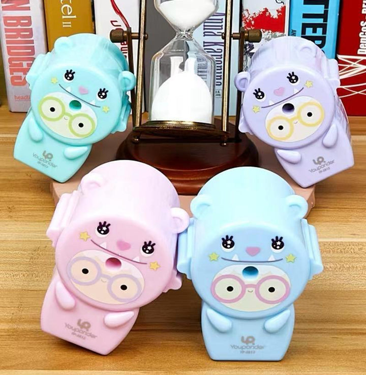 Cute Pastel Pencil Sharpener for KidsStationery > Erasers &amp; SharpenersCRAFTY CUDDLEFour cute cartoon - style sharpeners on a wooden surface with books in the background.Pink