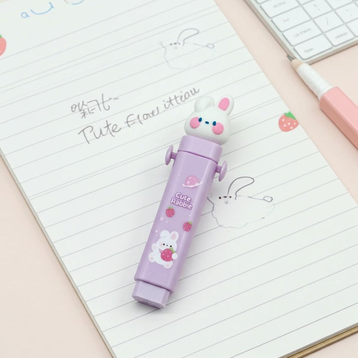 Cute Push - Pull Cartoon Erasers for KidsCRAFTY CUDDLECute rabbit - shaped purple eraser on a notebook page with a pink pen and keyboard in the background.Bunny