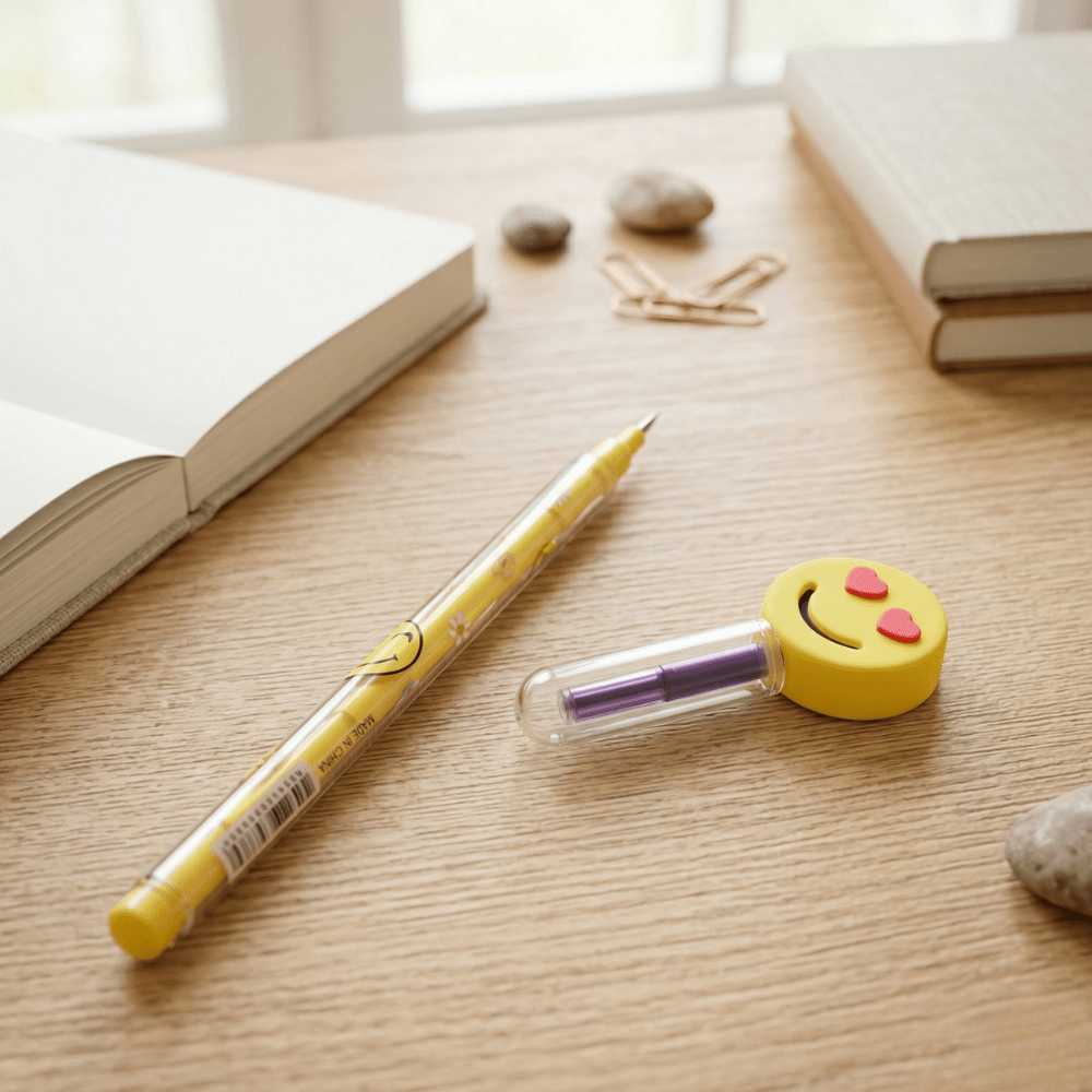 Emoji Fun Refillable PencilsCrafty CuddleYellow pencil with a smiley face design on a wooden surface1