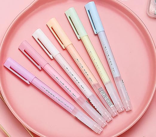 Set of colorful pens on a pink plate