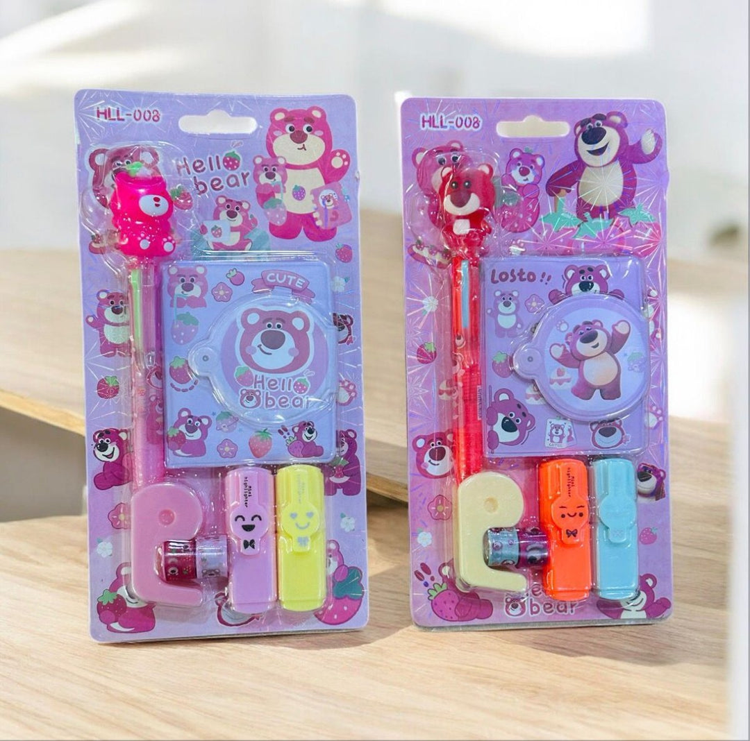 Two packages of cartoon bear-themed stationery items on a wooden surface.