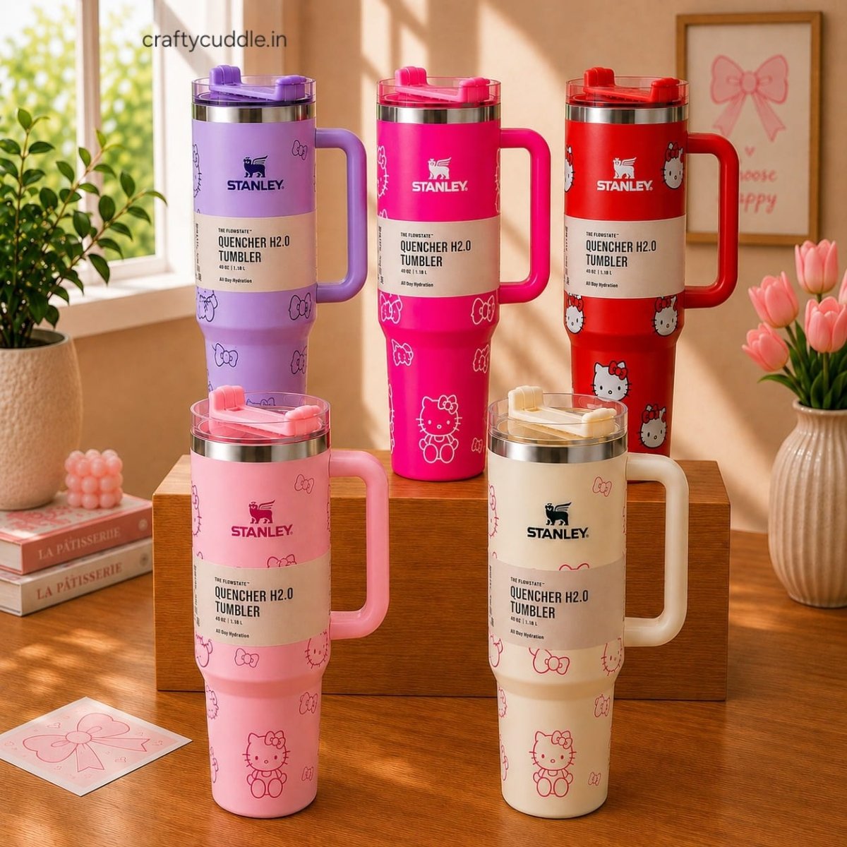 Hello Kitty Stainless Steel TumblerTumblersCrafty CuddleFive Stanley Quencher H2.0 tumblers with Hello Kitty designs in purple, pink, red, and cream, arranged on a wooden shelf and tabletop in a styled room setting.CreamHello Kitty Tumbler