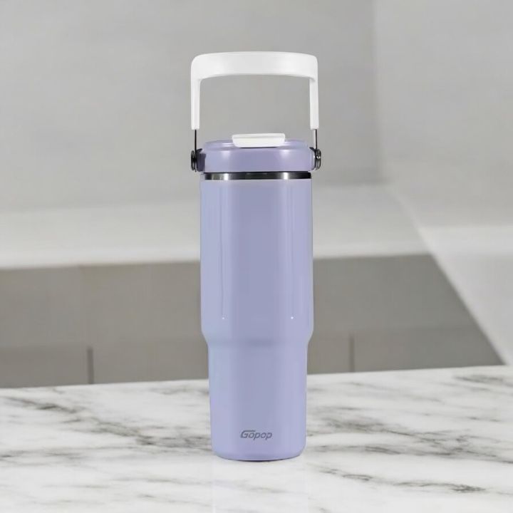 Purple water bottle with a white handle on a marble surface