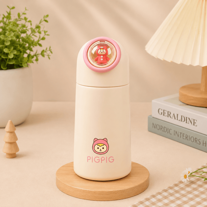 Kawaii Glass Drinking BottleCartoon Kids Water BottleCrafty CuddleA cream-colored glass bottle with a pink cartoon character and the text &