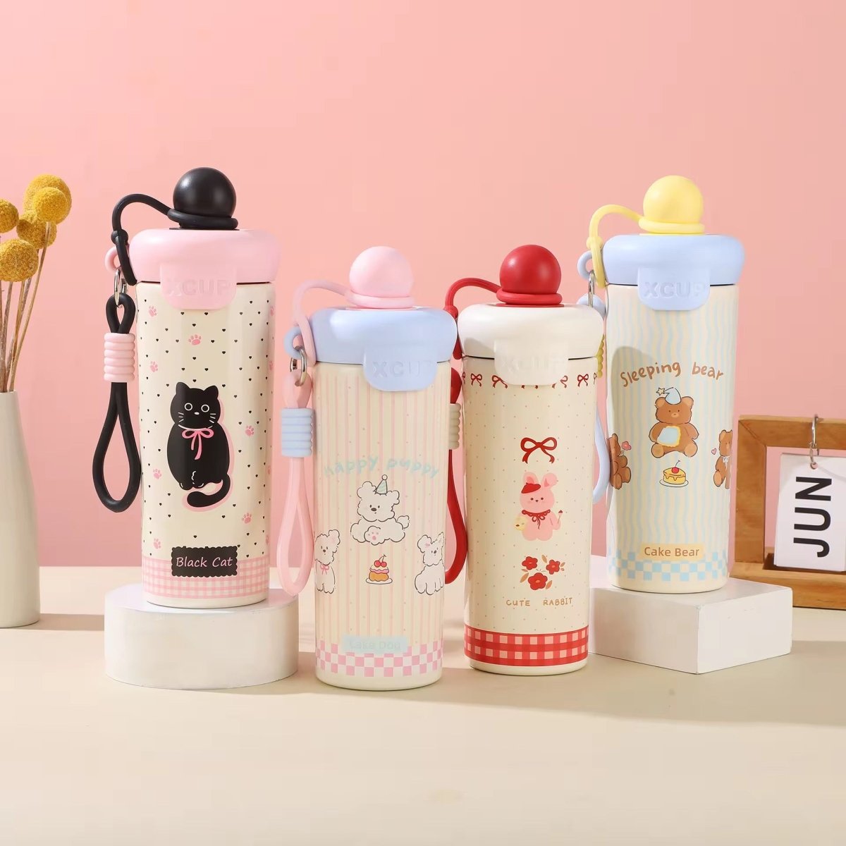 Kids Insulated Water BottleCartoon Kids Water BottleCrafty CuddleFour colorful water bottles with cartoon designs on a pink backgroundPinkStainlessSteelBottle InsulatedBottle WaterBottle KidsWaterBottle LeakproofBottle ReusableBottle SchoolEssentials TravelBottle HydrationOnTheGo CuteWaterBottle