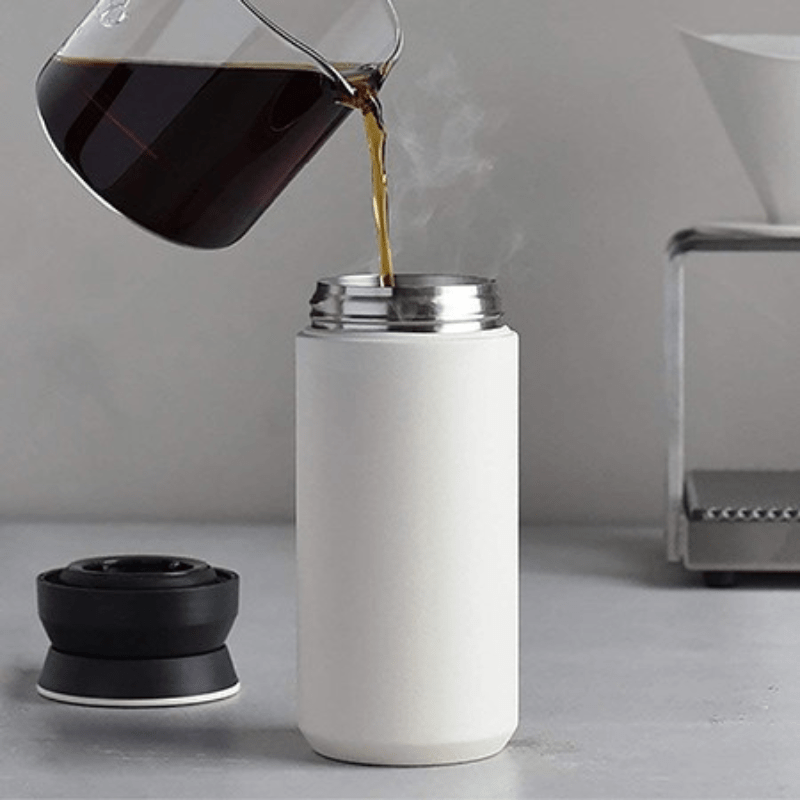 White 350ml insulated vacuum cup being filled with hot tea, stainless steel thermal bottle for keeping beverages warm