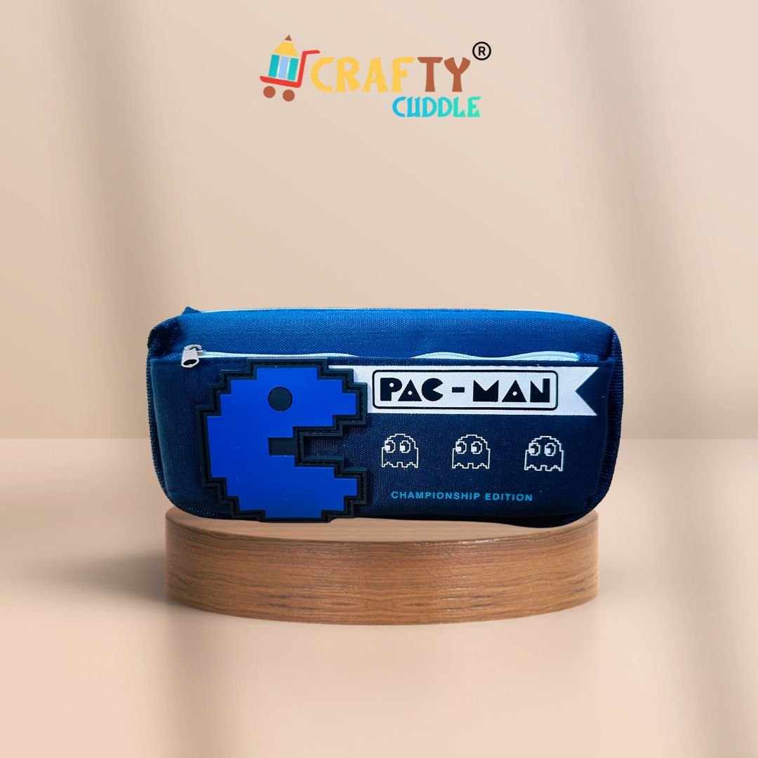 Pac-Man themed Dark blue pencil pouch for kids featuring a red pixelated Pac-Man design and ghost icons, labeled "Championship Edition", displayed on a wooden platform with a peach background. Crafty Cuddle logo on top.