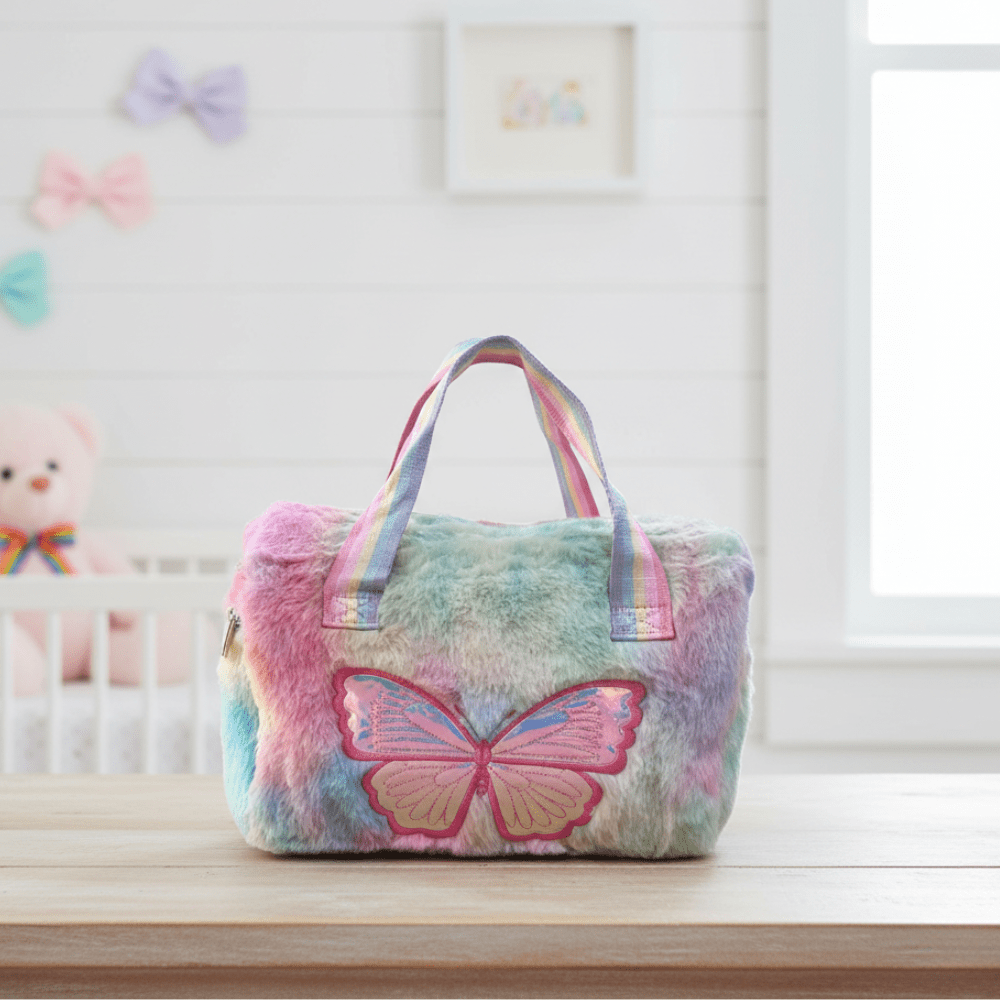 Pastel Butterfly Handbag for GirlsKids BagsCRAFTY CUDDLEMulticolored plush bag with a butterfly design on a surface, with a baby crib and colorful bows in the background.Multicolor