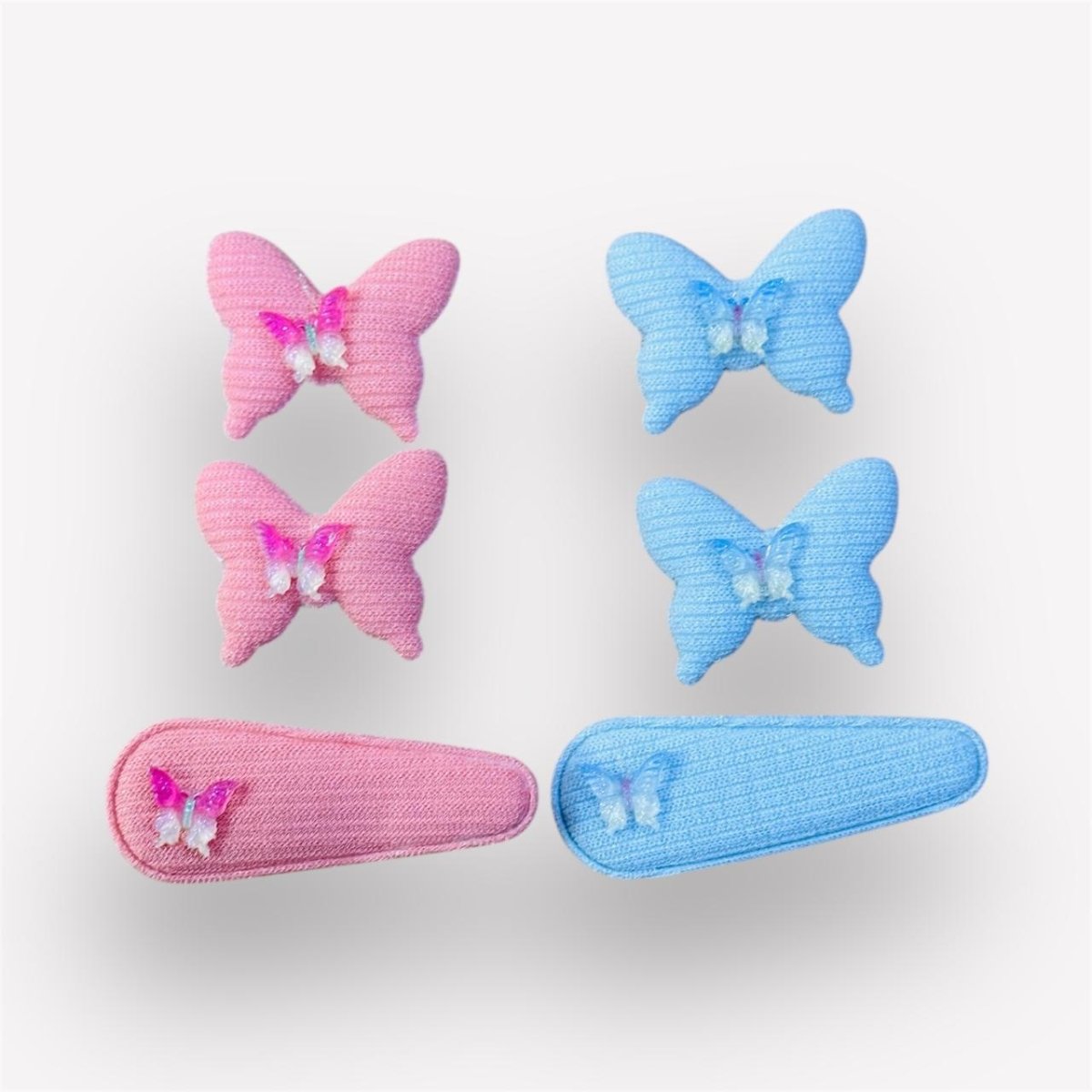 Set of pink and blue butterfly hair clips on a white background