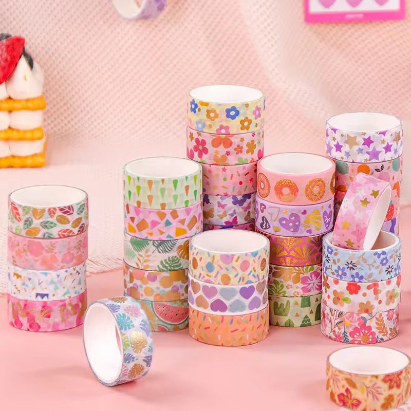 Pastel Pattern Washi Tape Mega SetDecorative Washi TapeCRAFTY CUDDLEStack of colorful washi tape rolls on a pink backgroundart journalingbotanical tape