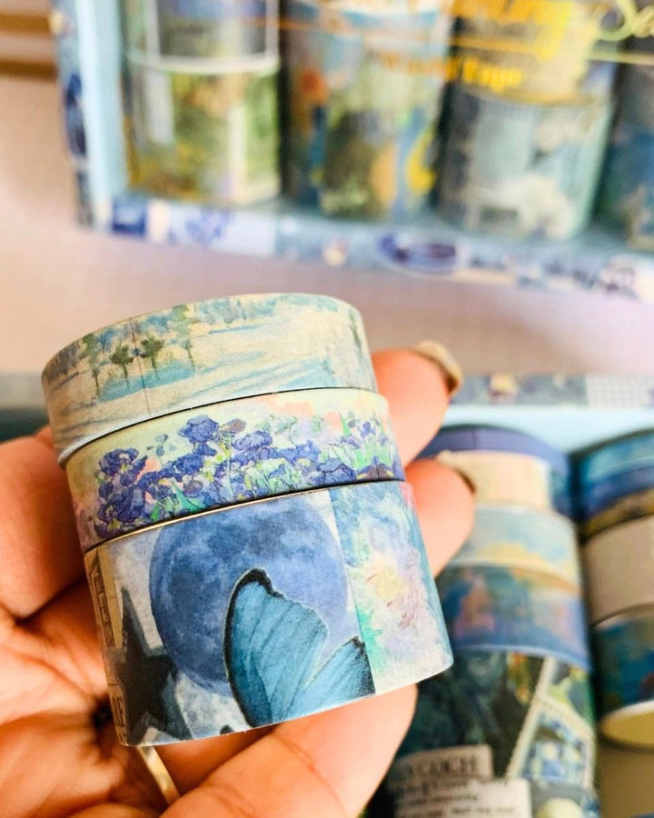 Washi tape with butterfly design held by a hand, with more tape in the background.