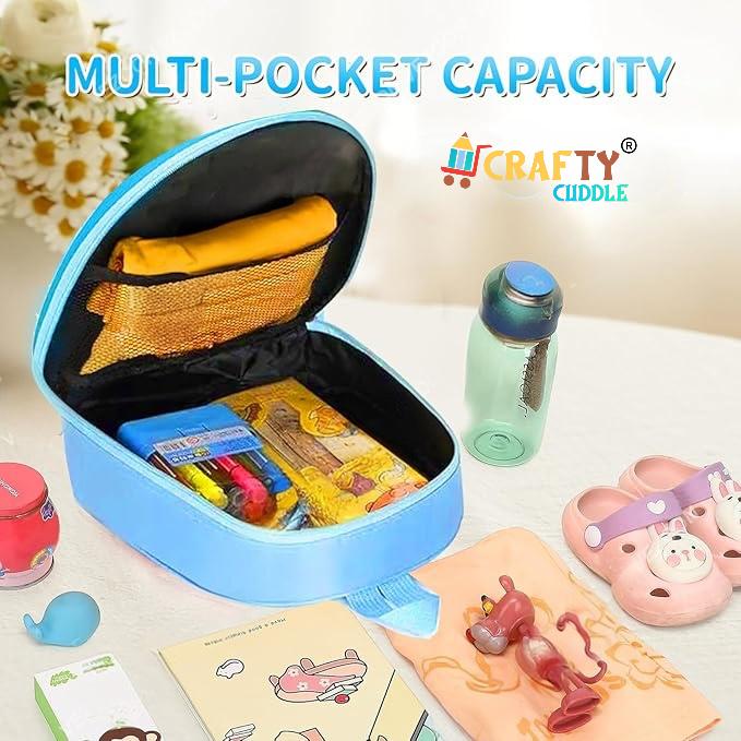 Blue multi-pocket capacity bag with stationery items on a light surface, featuring the brand 'CRAFty Cuddle'.
