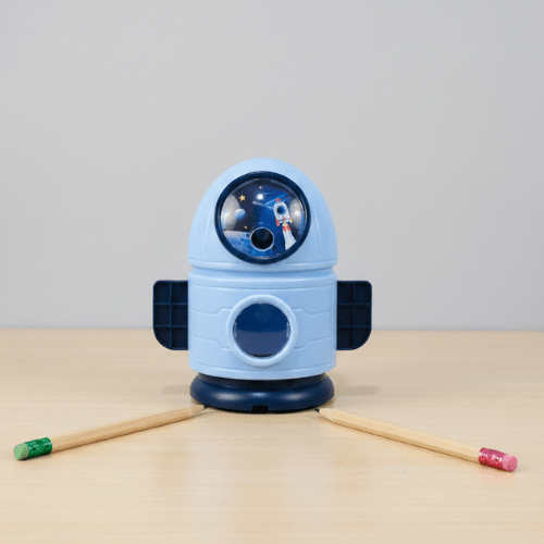 Space - Themed Pencil SharpenerStationery > Erasers &amp; SharpenersCRAFTY CUDDLEBlue robot - shaped pencil sharpener with two pencils on a beige surface and light gray backgroundSky BlueKidsStationery SpaceTheme CuteStationery SchoolSupplies KawaiiStationery BackToSchool StationeryAddict StudyEssentials ReturnGiftIdeas StationeryLove
