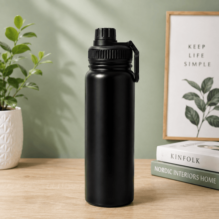 Stainless Steel Vacuum Water Bottle with Carry HandleInsulated Water BottleCrafty CuddleA matte black stainless steel water bottle with a carrying loop, standing on a light wood table next to a potted plant and a stack of books against a sage green wall.BlackVacuumBottle WaterBottle InsulatedBottle StainlessSteelBottle HotAndColdBottle TravelBottle GymBottle LeakProofBottle HydrationEssentials ReusableBottle