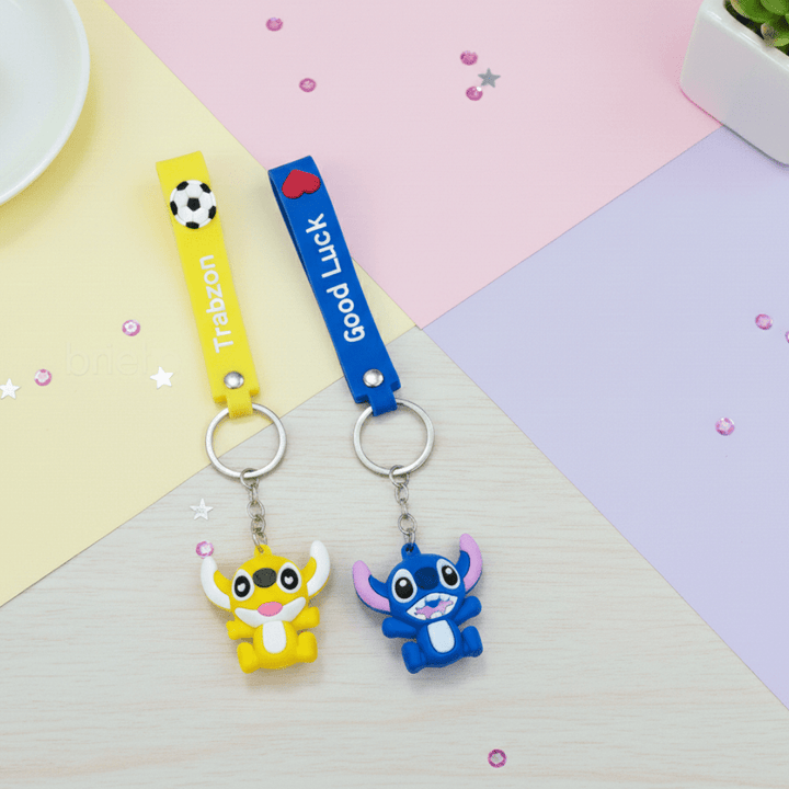 Stitch Theme Keychain with StrapKeychainsCRAFTY CUDDLETwo cartoon character keychains on a colorful geometric background1CartoonKeychain CuteKeyring MonsterKeychain KawaiiAccessories KidsBagCharm BackpackAccessory ReturnGifts TrendyKeychains SiliconeKeyring GiftForKids