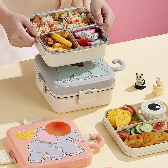 Gray elephant-themed bento lunch box with 'Super Elephant' design, opened to reveal a colorful meal—rice with vegetables, dragon fruit, cherry tomatoes, and donuts. Includes a spoon and cute figurines, placed on a beige table with a soft pink background. Ideal for kids’ meals, school lunches, and reusable food storage solutions