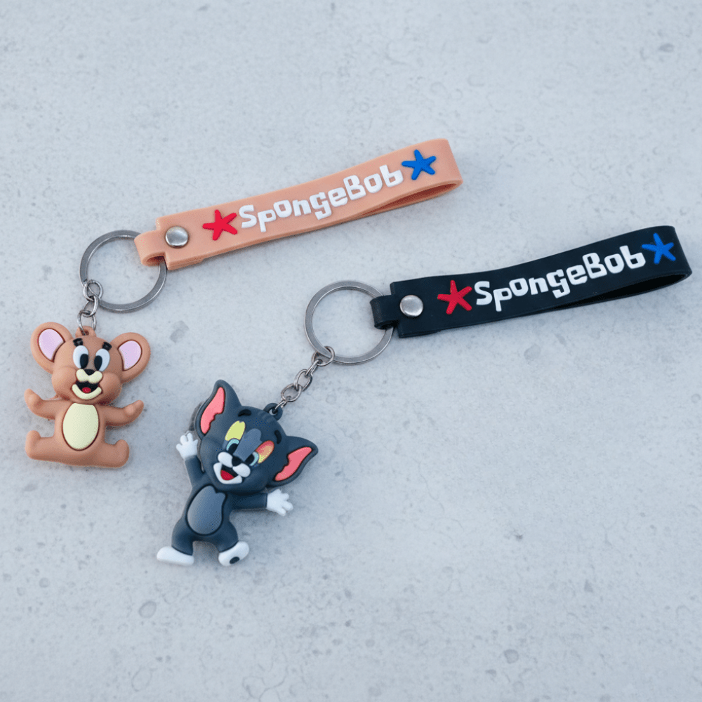 Tom &amp; Jerry Cartoon Silicone KeychainKeychainsCRAFTY CUDDLETwo keychains featuring cartoon characters on a gray surface with &