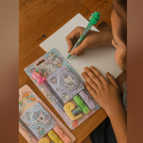Unicorn Stationery Gift SetStationery SetsCRAFTY CUDDLEChild using a green pen with a cartoon design, next to stationery items on a wooden table.BackToSchoolCuteStationery