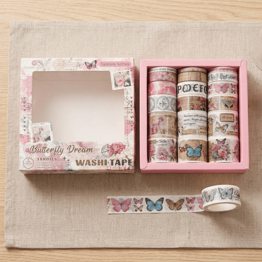 Set of washi tapes with decorative designs in a pink box on a beige surface.